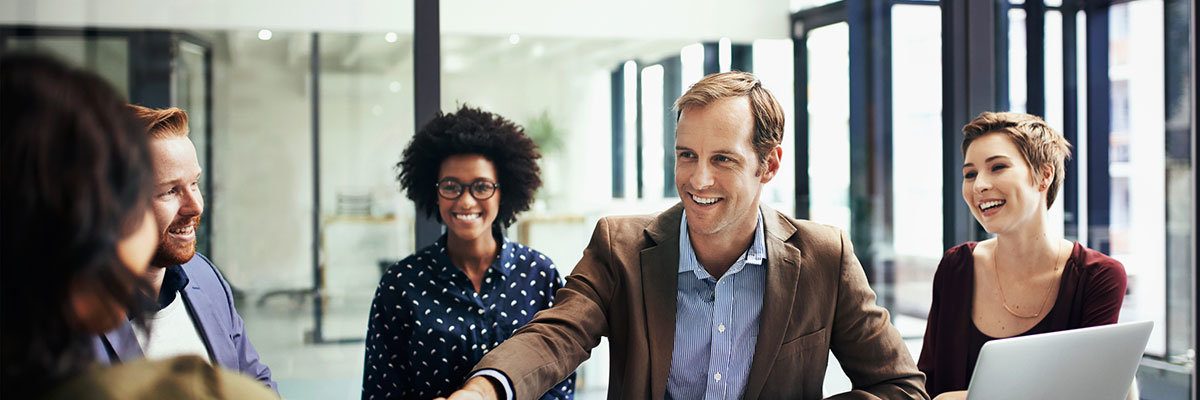 Developing business interests by striking up a deal Shot of colleagues shaking hands during a meeting at work